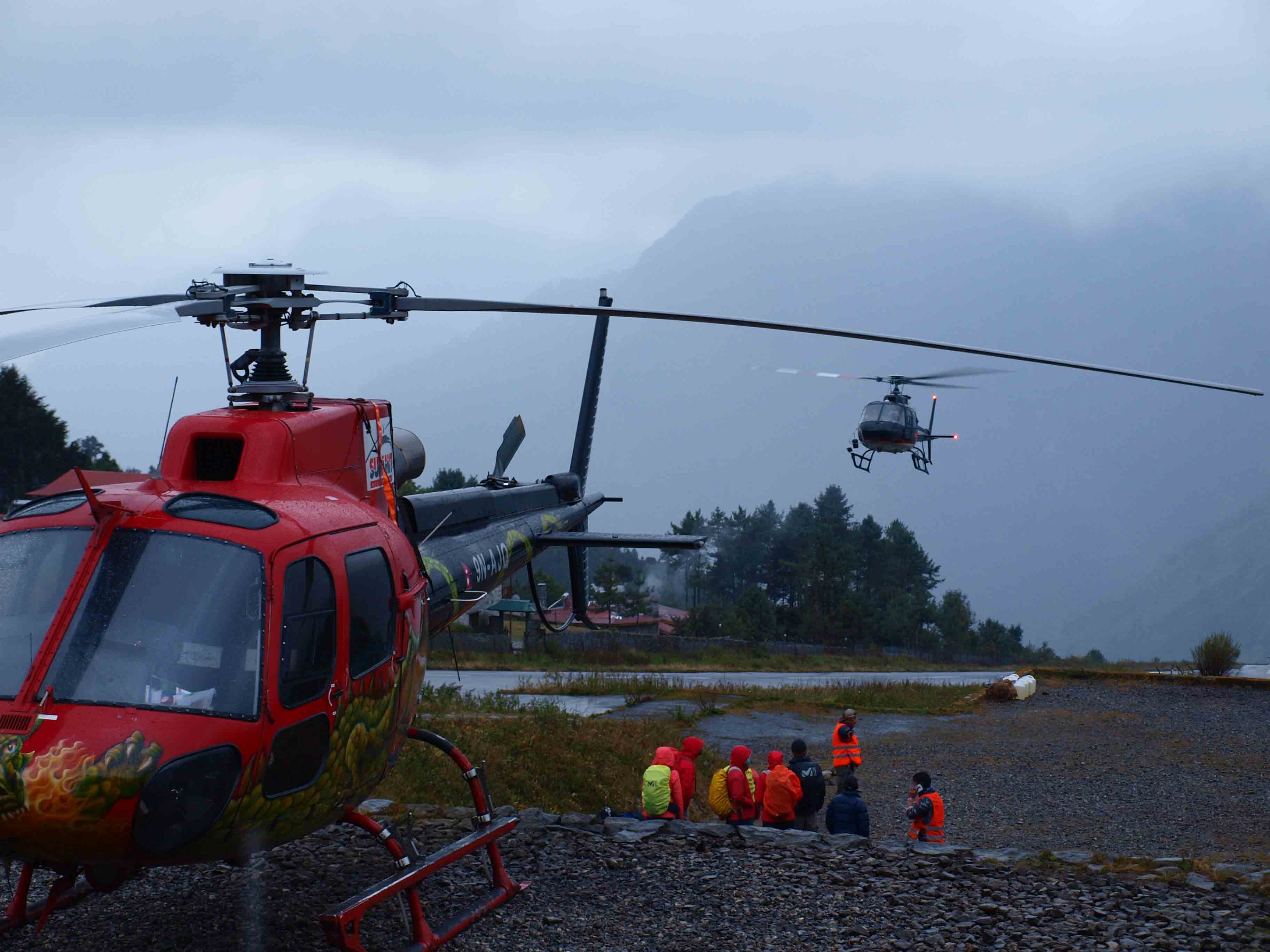 Helicopter arriving and people getting ready to board nepal lukla